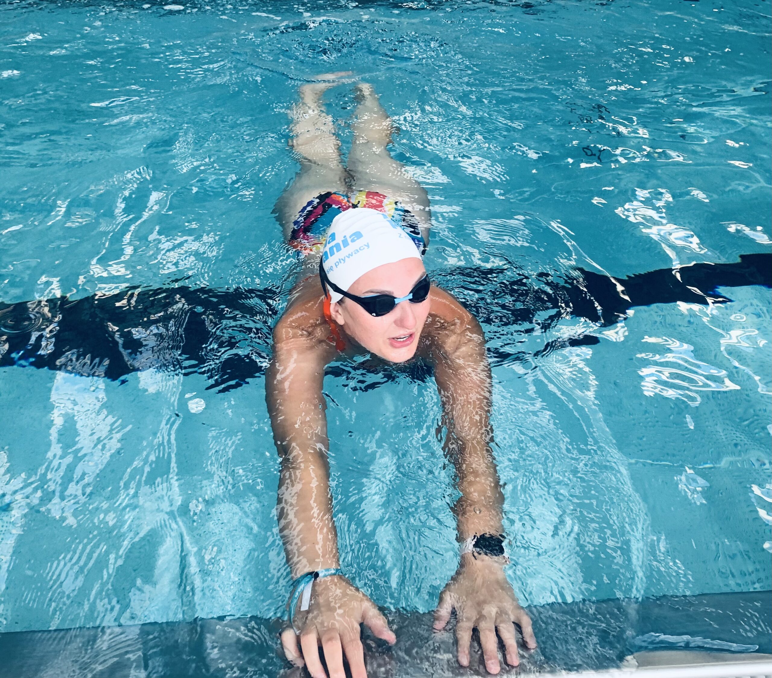 Kobieta w stroju pływackim w basenie podczas zajęć Kuźni Pływania